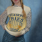 Person wearing a polka dot shirt and a sweater with a visible brand logo on a blue background