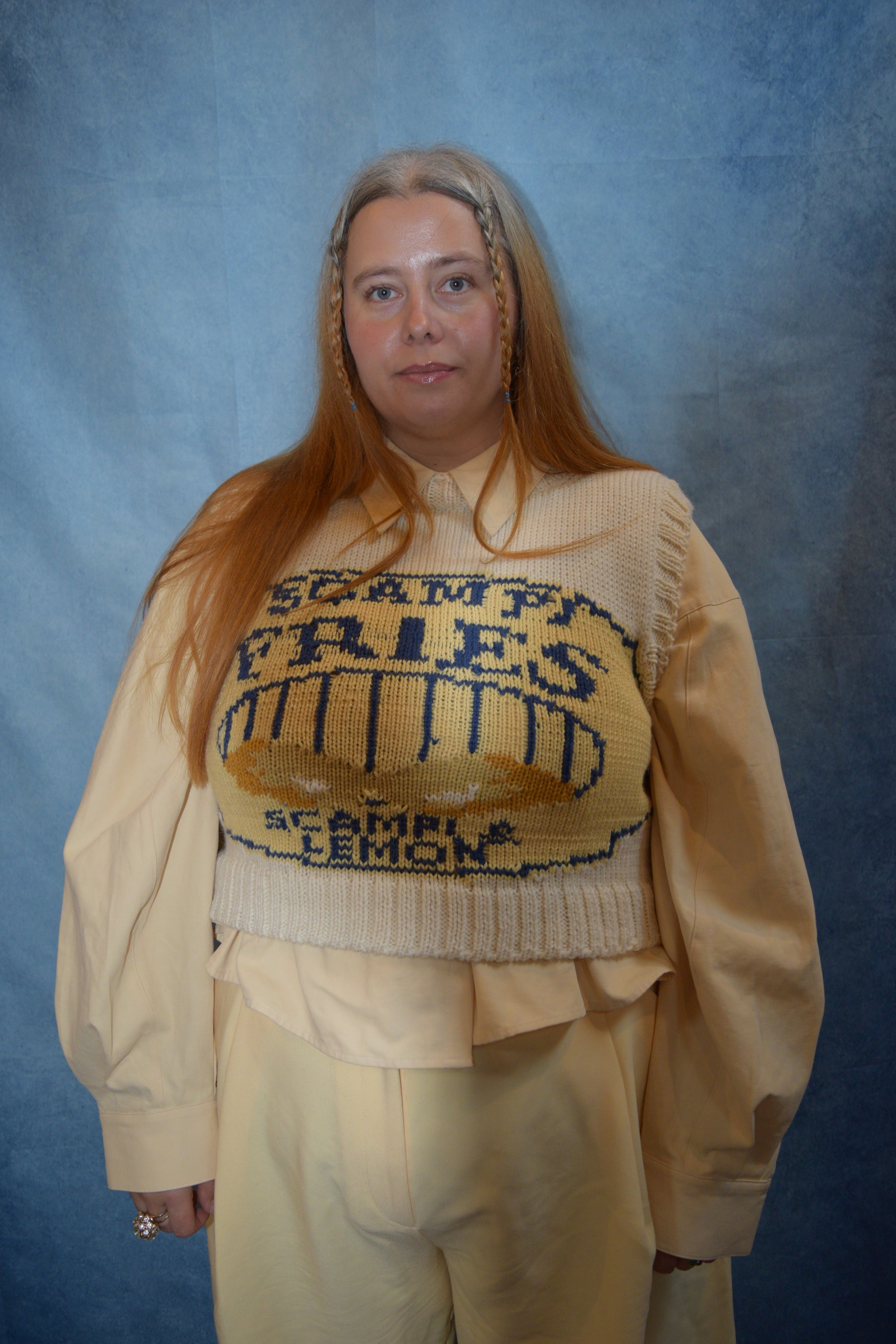 Person wearing a beige sweater with text on a blue background